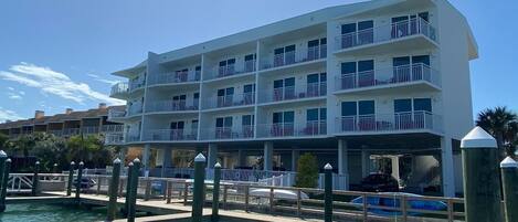 A multi-story hotel with balconies, a dock, and a pool.