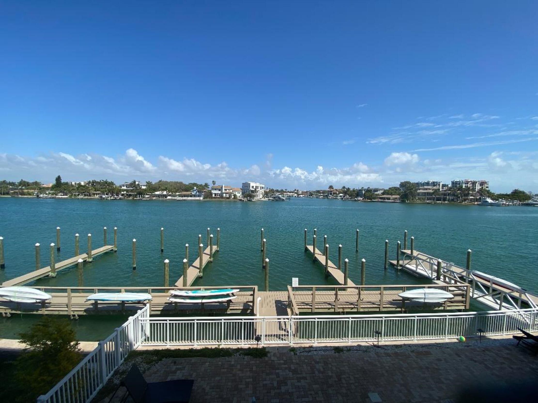 A marina with docks and boats, a clear sky, and buildings in the background.