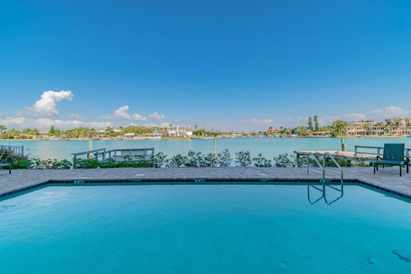 A swimming pool with a view of a body of water and buildings in the background. - Oceana 202 West (Treasure Island)