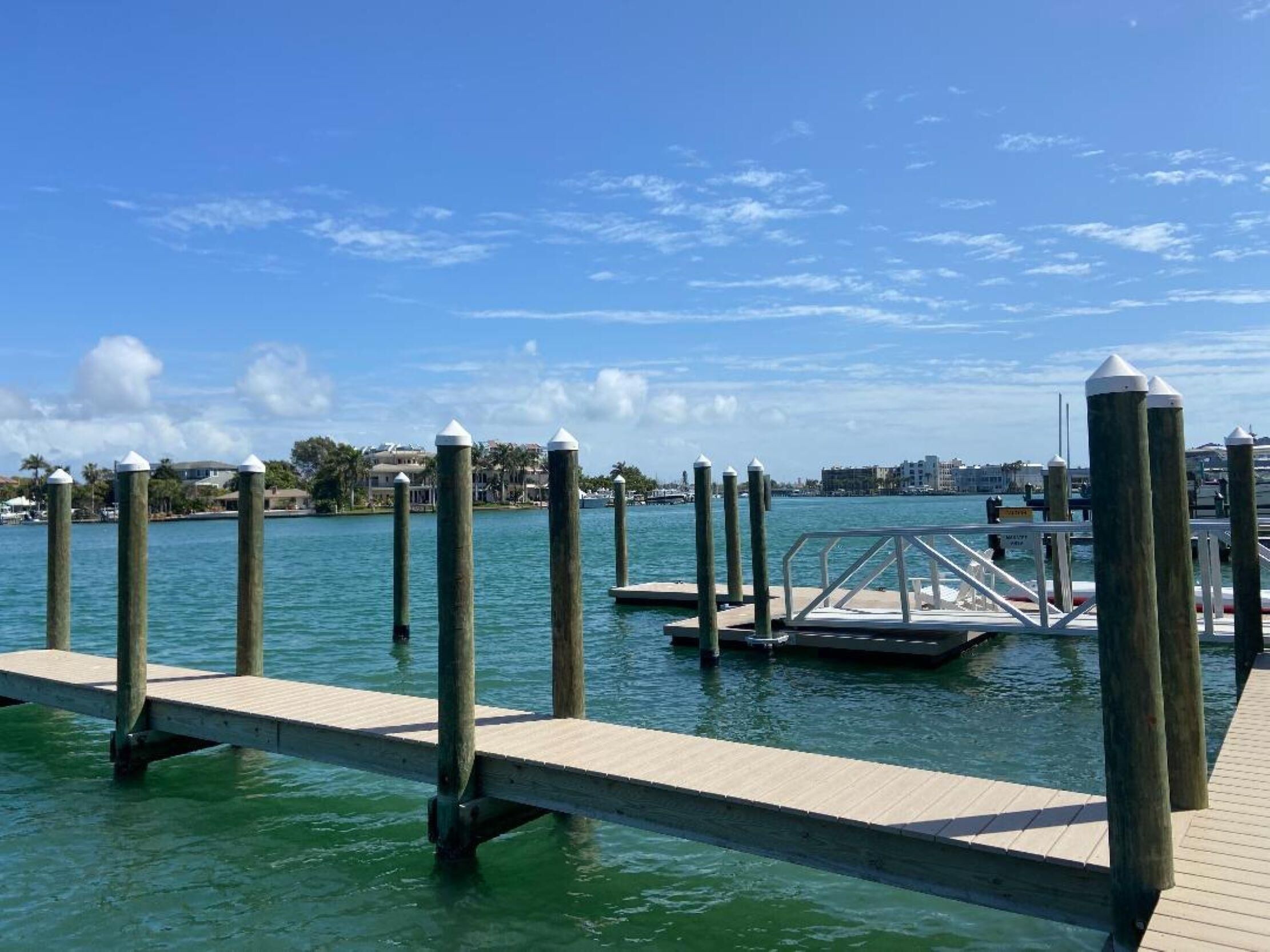 A wooden dock extending into calm water with a clear sky above.