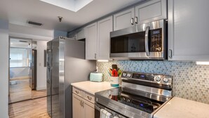 A modern kitchen with stainless steel appliances, a microwave, and a toaster. - Pelican Pointe 2C (Indian Shores)