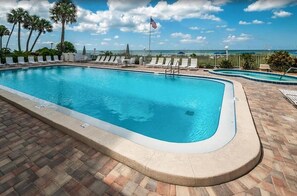 Relax by the pool surrounded by a comfortable deck and lounge chairs with ocean views.