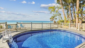 A swimming pool with a wooden deck and a view of the ocean. - Serenity By The Sea (Treasure Island)