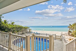 A pool area with a view of the beach and ocean. - Serenity By The Sea (Treasure Island)