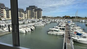 A marina with numerous boats docked, surrounded by multi-story buildings.