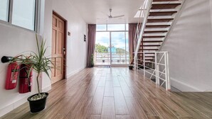 A spacious hallway with wooden flooring, a ceiling fan, and a staircase on the right. - Raalhu Fonu Maldives  (Mahibadhoo)