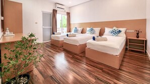 A hotel room with three beds, a desk, a plant, and a ceiling fan. - Raalhu Fonu Maldives  (Mahibadhoo)