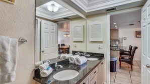 A bathroom with a large mirror, two sinks, and a vanity.