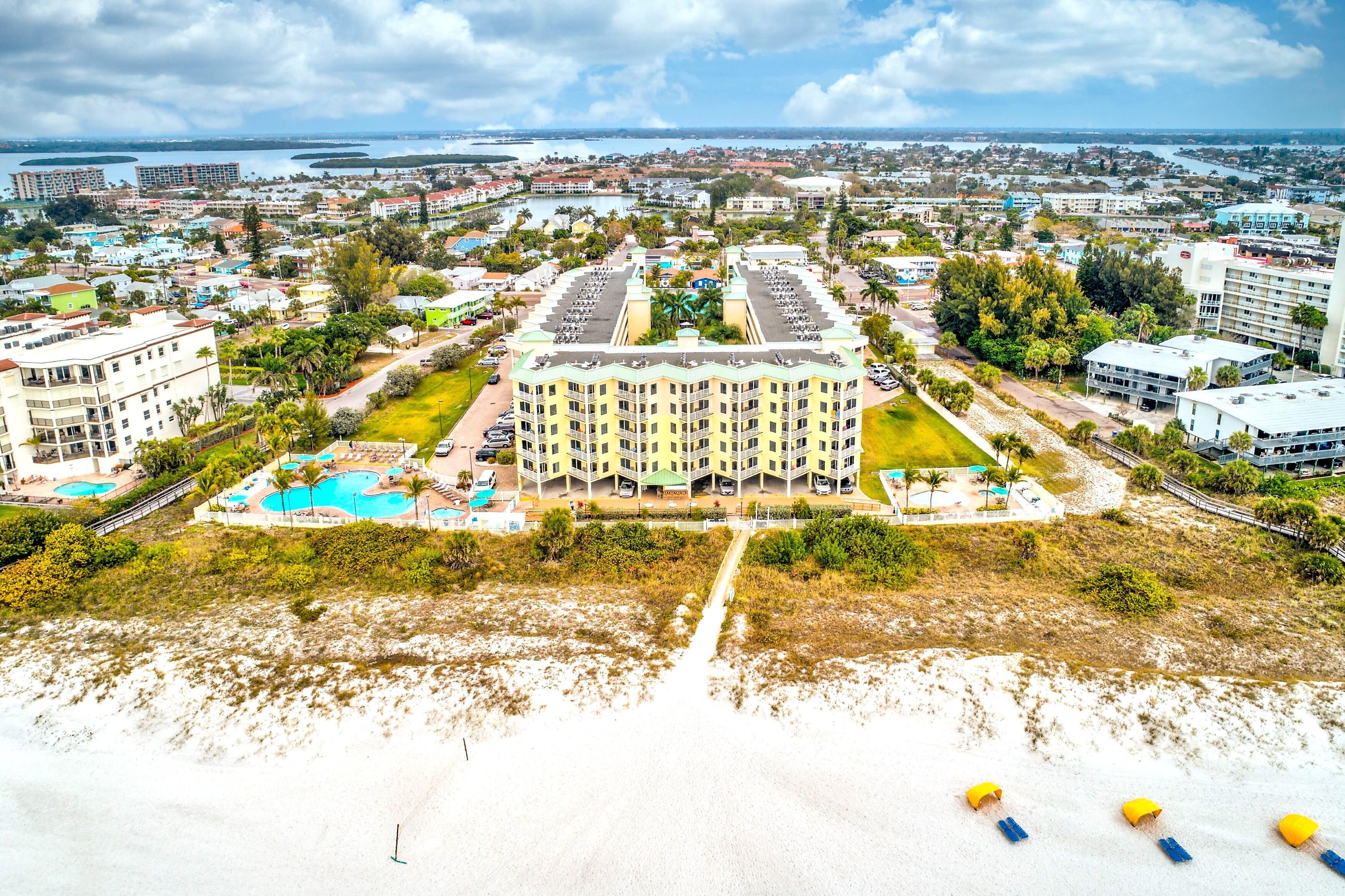 A hotel with multiple floors, a central courtyard, and a pool area.