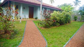 A house with a tiled roof, a covered porch, and a gravel pathway leading to the entrance.