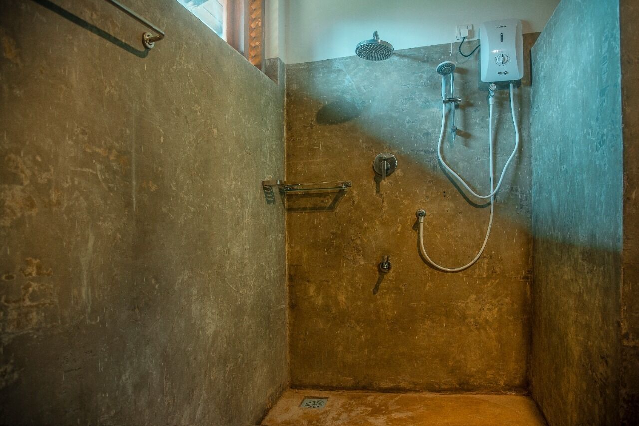 Een douche met een handdouche en een kraan op de muur.