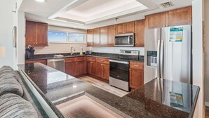 A modern kitchen with wooden cabinets, stainless steel appliances, and a large island.