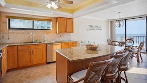 A spacious kitchen with wooden cabinets, a granite countertop, and a large island. - Trillium 2A - Premier (Madeira Beach)
