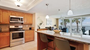 Una cocina con armarios de madera, electrodomésticos de acero inoxidable y una isla grande con taburetes de bar.