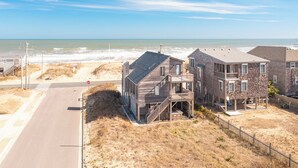 A beachfront property with a road, stop sign, and a sandy beach. - Sun Realty pet-friendly semi-oceanfront home with incredible views! (Kill Devil Hills)