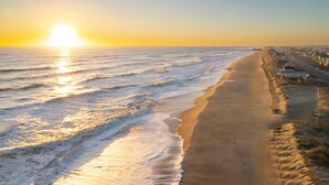 A beach with a row of houses along the shore. - Sun Realty pet-friendly semi-oceanfront home with incredible views! (Kill Devil Hills)