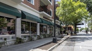 A storefront with outdoor seating and a sign that reads "Sunnyside Steamers." - Chic 2BR Apt, Steps from N Main St, Balcony View
 (Greenville)