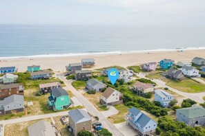 Une zone résidentielle côtière avec des maisons, une plage et un ciel dégagé.