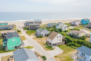 Un quartier résidentiel situé sur la côte, avec des maisons, une plage et une vue dégagée sur l’océan.