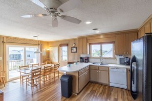 Una cocina amplia con armarios de madera, una isla central, lavavajillas y refrigerador.