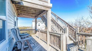 A wooden deck with a staircase leading to a house. - Pet-friendly oceanside home in Corolla w/ pool and hot tub! (Corolla)
