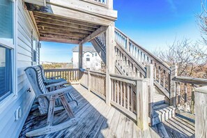 A wooden deck with a staircase leading to a house.