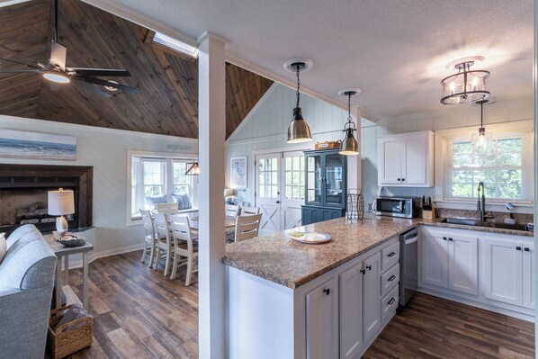 Kitchen area with central island, microwave, sink, and dining space.