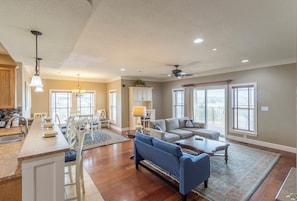 A spacious living area with a kitchen, dining table, and a large sofa.