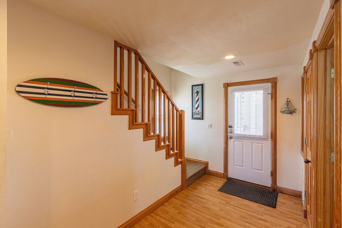 A staircase with wooden railings leading to a door with a window.