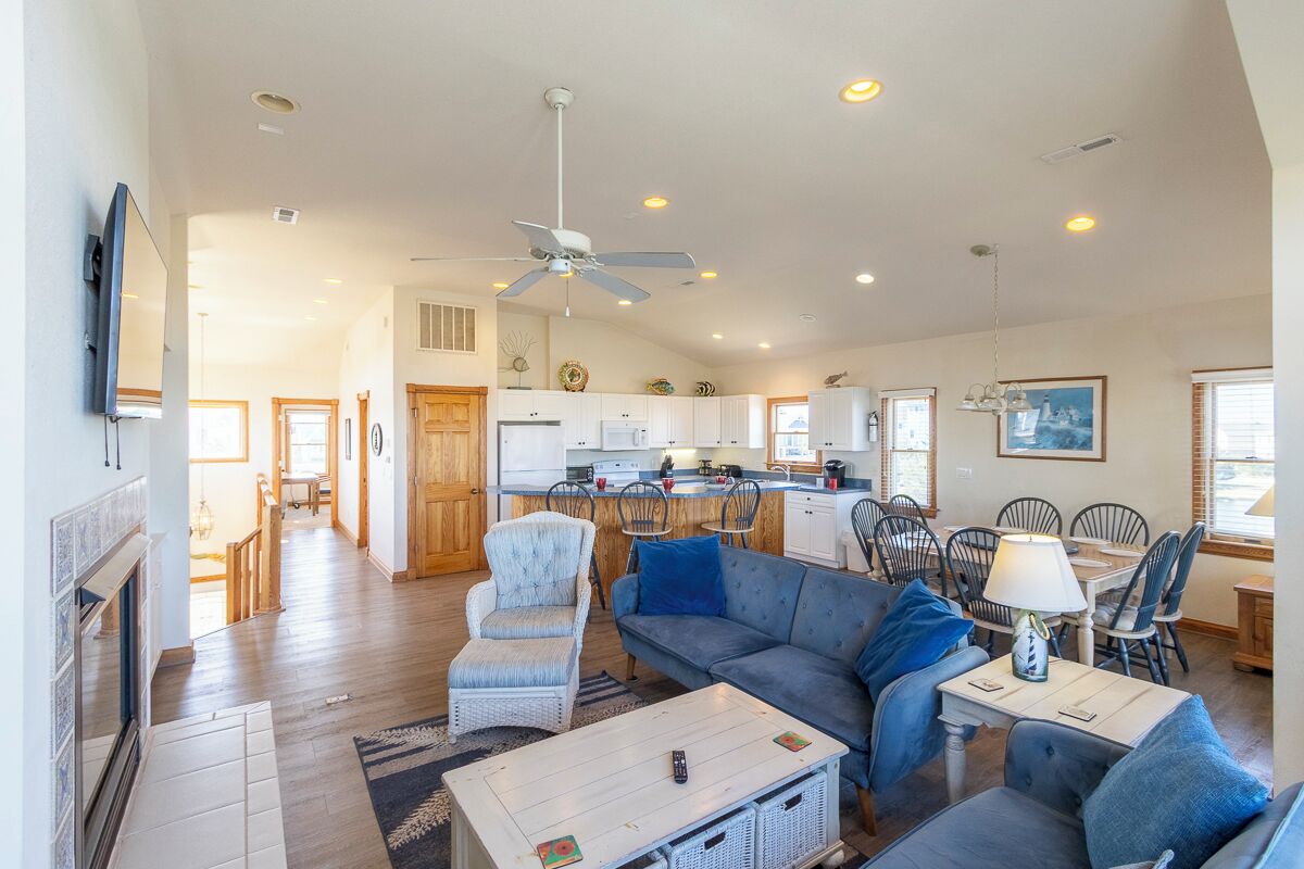 A spacious living area with a sofa, chairs, a coffee table, and a television.