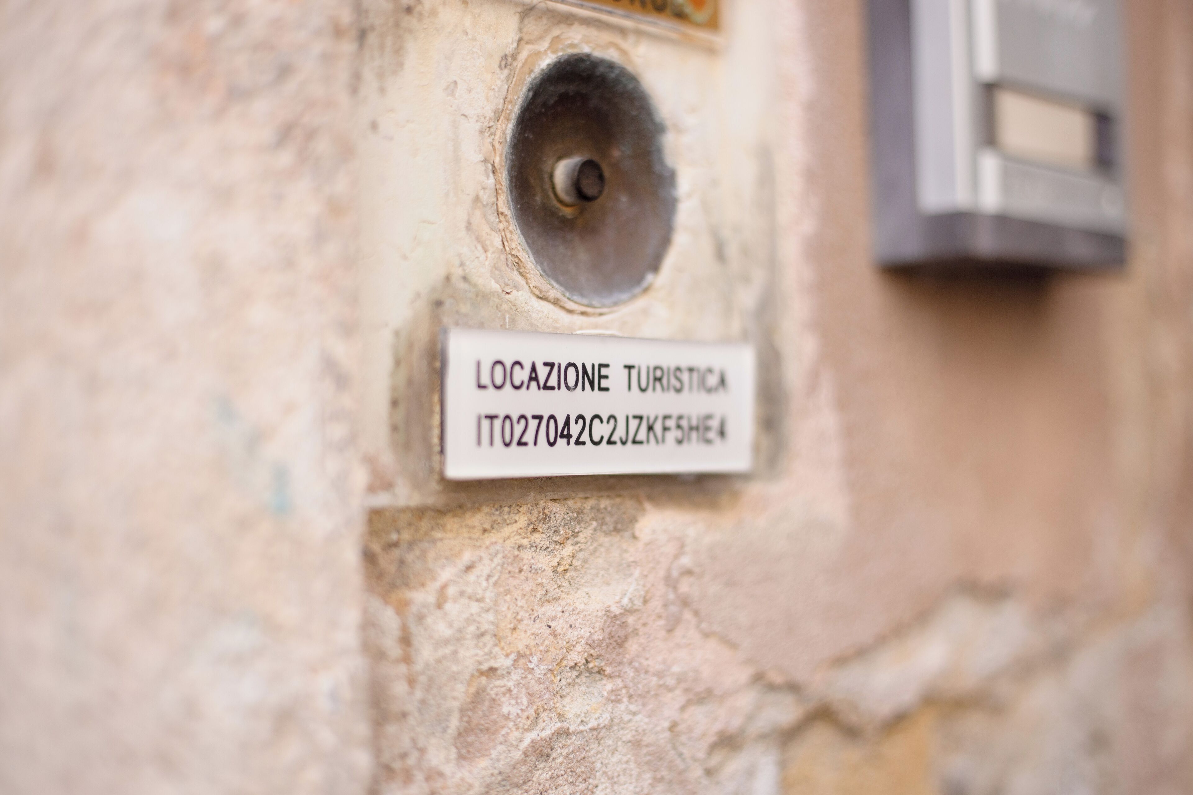 Et nærbillede af en væg med et skilt, der siger "LOCALE TURISTICA" og en adresse.