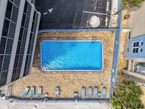 An aerial view of a swimming pool with lounge chairs and a tiled deck. - Villa Madeira 208 (Madeira Beach)