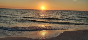 A sunset over a calm sea with gentle waves.