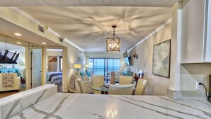 A spacious living area with a large marble countertop, a chandelier, and a view of the outdoors. - Villa Madeira 406 (Madeira Beach)