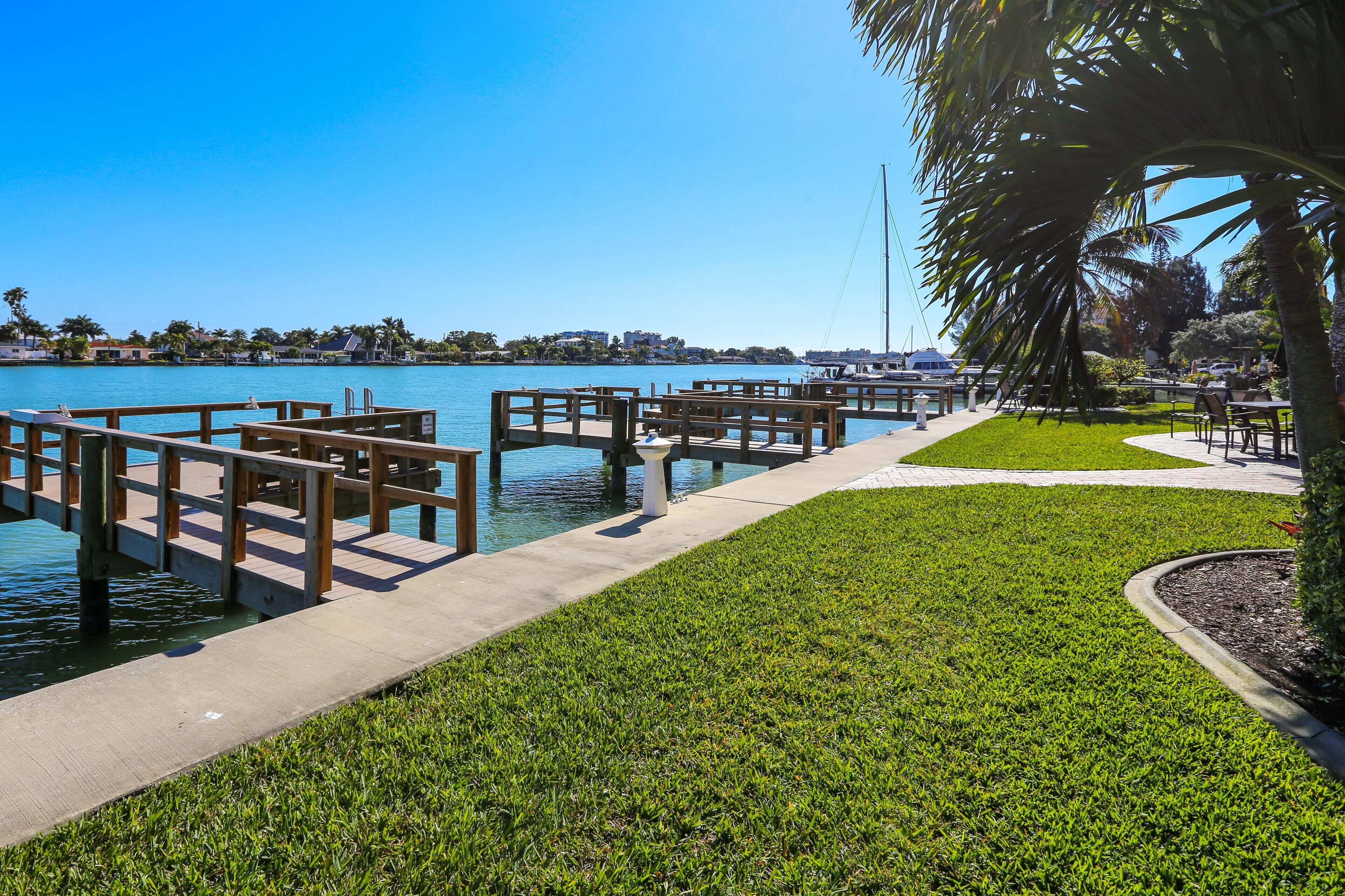 A marina with wooden docks and a grassy area.