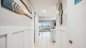 A hallway with white walls, a tiled floor, and a view to the outside. - Holiday Villas II 407 Premier (Indian Shores)