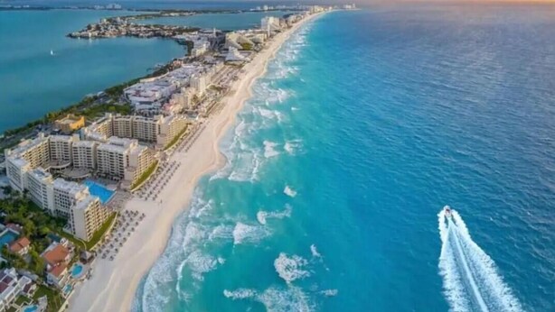 An aerial view of a coastal resort with beachfront hotels, a marina, and a clear view of the ocean. - Holiday Villas II 407 Premier (Indian Shores)