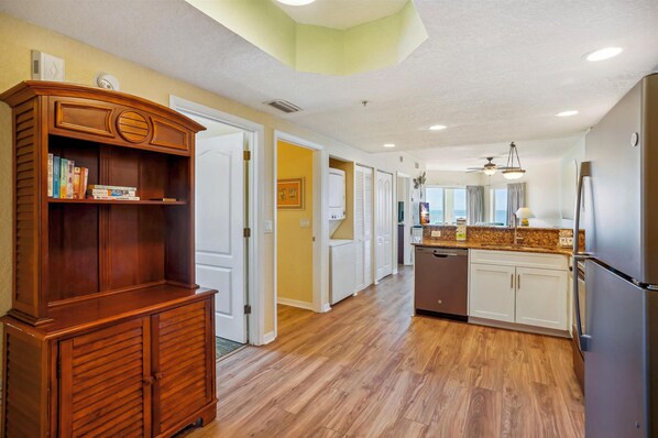 A kitchen with wooden cabinets, a built-in bookshelf, and a refrigerator.