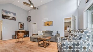 A spacious living room with a grey sofa, a patterned armchair, a wooden coffee table, and a wooden rocking chair. - (A)  Elora Grand River Suite (Elora)