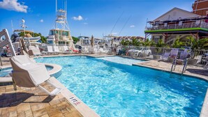 A swimming pool with lounge chairs and a lifeguard stand. - Madeira Bay Resort I 1502 (Madeira Beach)