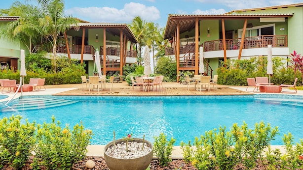 A pool area with lounge chairs and a small garden. - IT22 Lindo Apto 3 Quartos a Beira Mar (Camaçari)