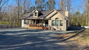 A single-story house with a porch, a chimney, and a fenced yard. - Spacious 3-bedroom house in the Poconos. (Blakeslee)