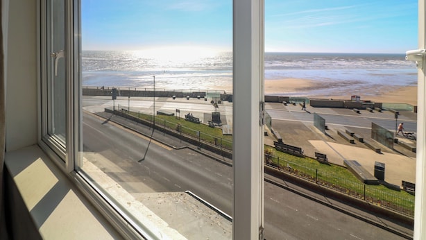 A view through a window of a coastal street with a beach in the background. - Apt 8 @ Hunter's Quay (Bridlington)