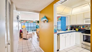 A kitchen with white cabinets, a microwave, and a stove.