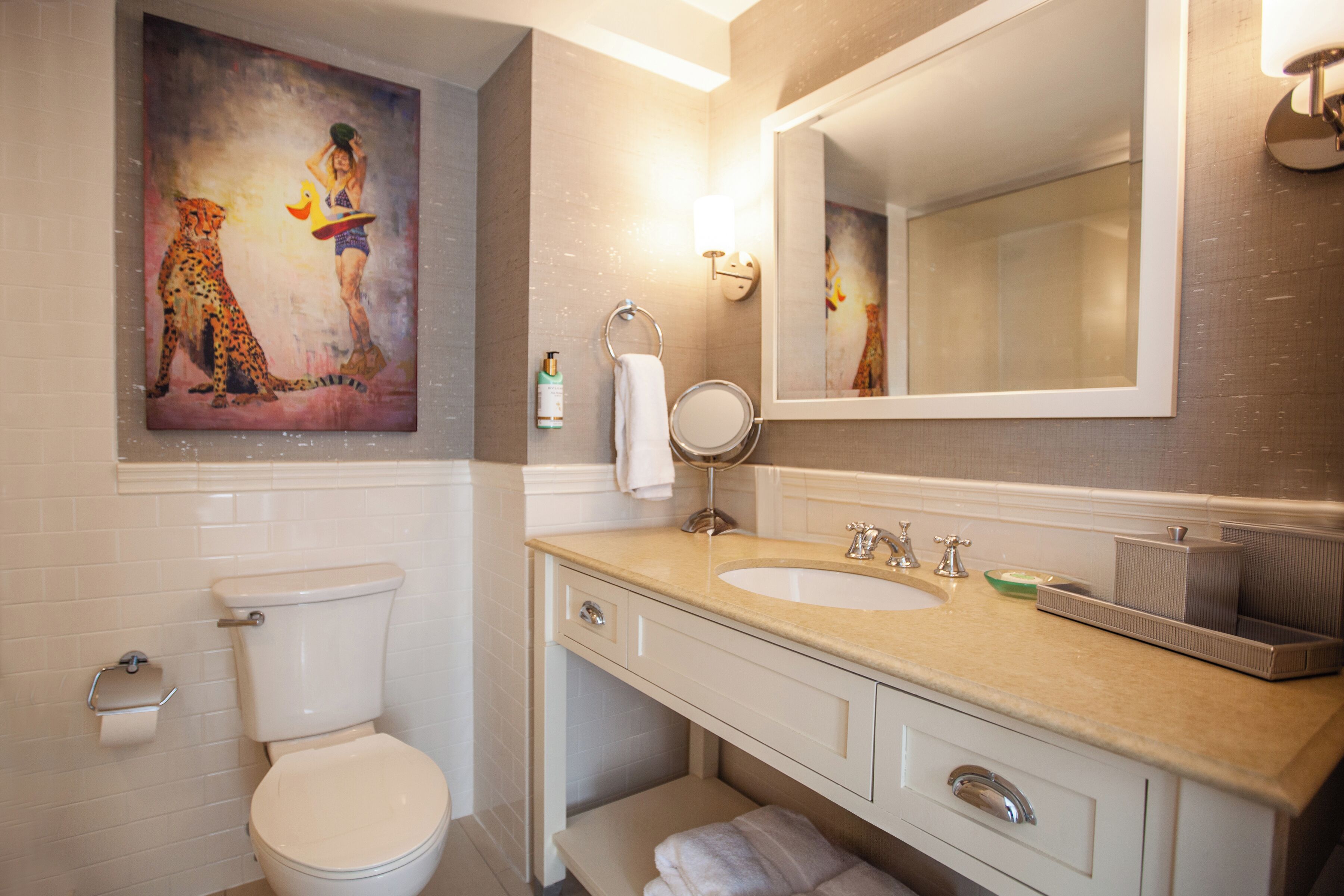 Ein Badezimmer mit Toilette, Waschbecken, Spiegel und einem Bild an der Wand.