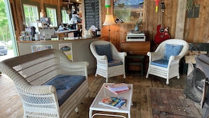 A cozy cafe with wicker furniture, a coffee bar, and a rustic wooden interior. - Oceanfront Cottage at Acadia National Park, Bar Harbor/Sea Glass Cottage (Bar Harbor)