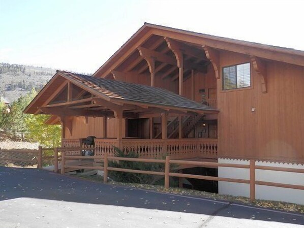 A wooden cabin with a porch, a covered entryway, and a small window.