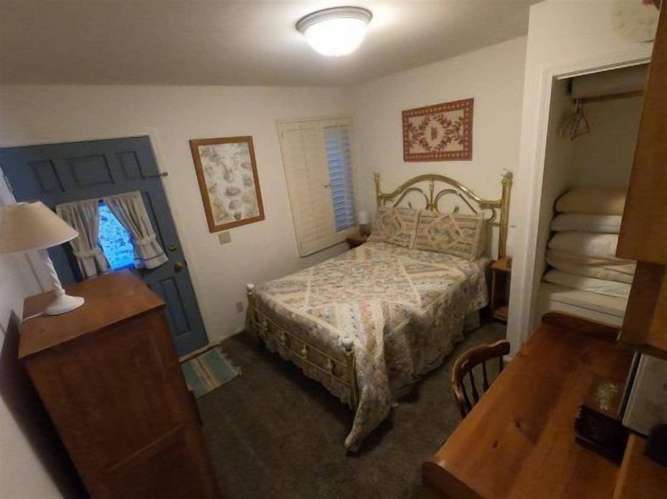 Un dormitorio con cama, cómoda y puerta de marco azul.