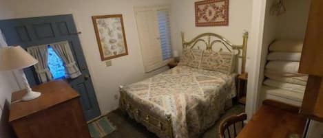 Un dormitorio con cama, cómoda y puerta de marco azul.
