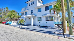 A two-story white house with a balcony, a driveway, and a mailbox. - Beach Livin 2 - 1 Bedroom Downstairs (Treasure Island)